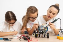 girls-and-female-teacher-doing-science-experiments-together-with-robotic-car (1)